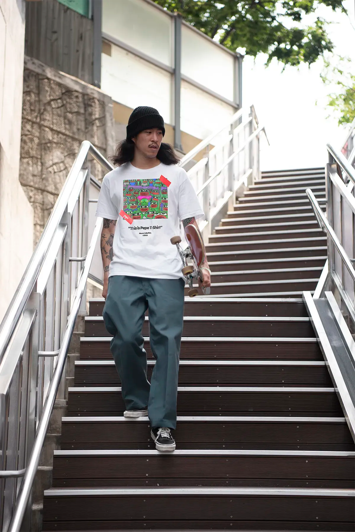 Skater wearing ironic meme shirt with multiple Pepe faces, urban outfit with beanie and skateboard