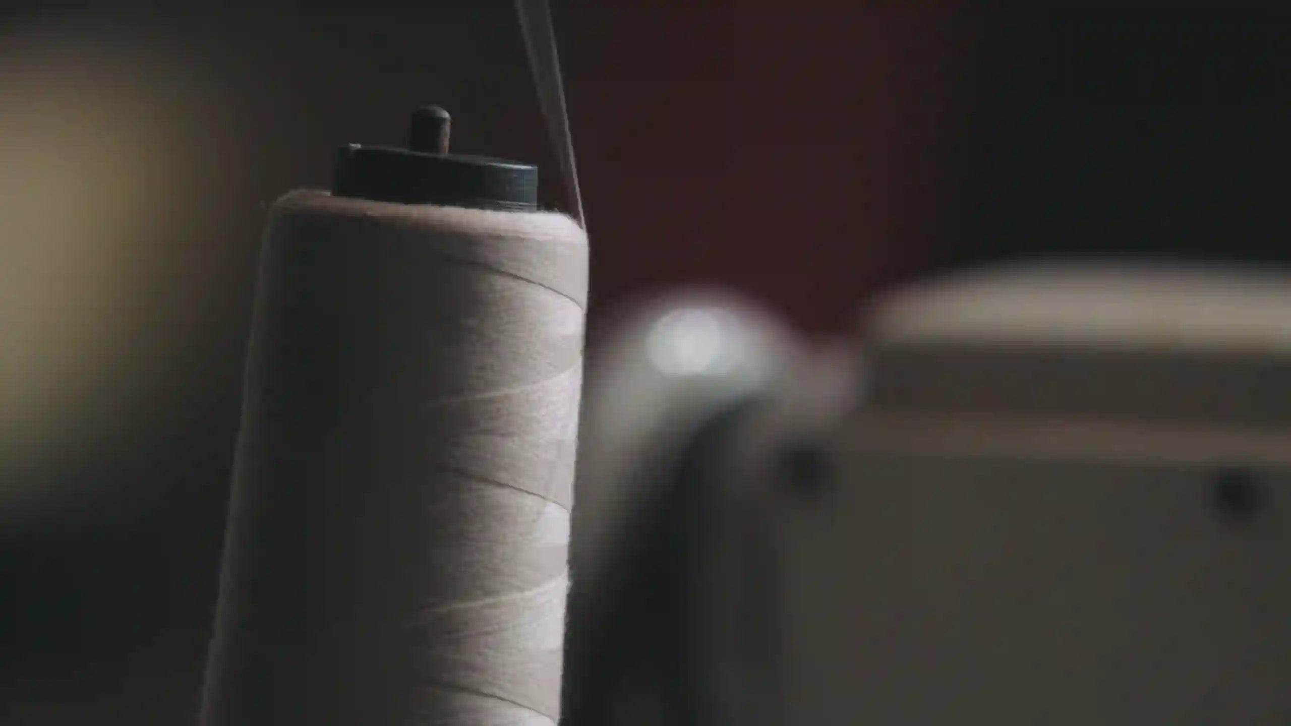 OUR PROMISE Image of a thread spool on a sewing maschine | Our Production in Turkey for Streetwear inspired by Crypto | CUKIDRIP Crypto Apparel